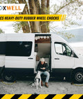 Heavy Duty Rubber Dual Wheel Chocks Set For RVs, Trailers And Trucks, shown under a parked van, 30 inch nylon rope, reflective tape