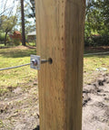 Professional Grade Tough As Nails One Way Anchor Wire Vise Heavy Duty Zero Slack Grip Clamp For 8 To 11 Gauge Solid Stainless Steel Cable Rigging Hardware Pack Of 10 attached to a wooden post.
