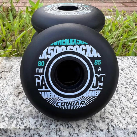 Inline Skate Wheels 4 Pack For Outdoor Indoor Use 78mm 80mm 85A With Bearings Roller Hockey Replacement Wheels Versatile Recreation Skates Smooth Glide And Dope Grip For A Smooth Long Lasting Ride. Front view of two black inline skate wheels with white text on a stone surface.