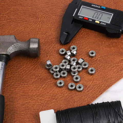 693ZZ Double Shielded Deep Groove Ball Bearings Kit 30Pcs displayed with caliper and hammer for size reference