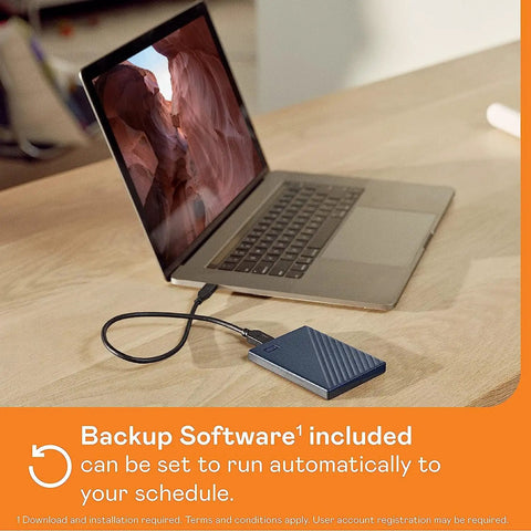2TB Portable External Hard Drive For Mac Navy With Backup Software shown connected to a laptop via USB cable on a wooden desk