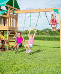 Rock Solid Heavy Duty Swing Hanger Kit With Ball Bearings For Porch And Patio Gliders installed on a wooden swing set with children playing.