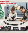 Father and son assemble Electric Train Set For Kids With Steam Locomotive And Cargo Cars Tracks And Railway Kit next to Christmas tree.