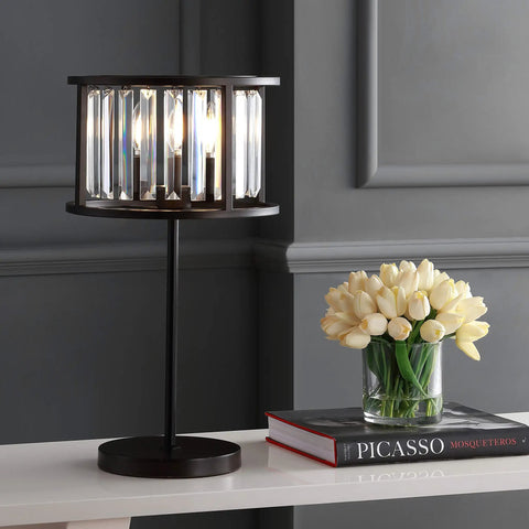 Oil Rubbed Bronze Two Light Metal And Crystal Table Lamp With Traditional Geometric Bedside Design For Living Room Or Bedroom, Linear Crystals, LED Bulbs Included, 21.5 Inch Tall on a table beside flowers and books