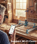 Man uses phone to control Desktop 4040 Pro CNC Milling Machine With Four Axis Ready and WiFi Module in woodworking shop