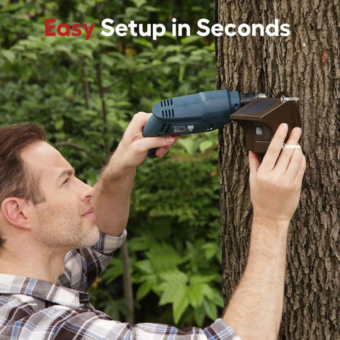 Installation of Pro 4 Smart Solar Driveway Alarm with 2.4G Wi Fi Real Time App Alerts and Motion Sensor on a tree by a man with a drill.