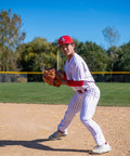 Baseball player wearing Pro Weight Four Way Stretch 14 Ounce Tapered Baseball Pants For Adults White With Black Pinstripes in action