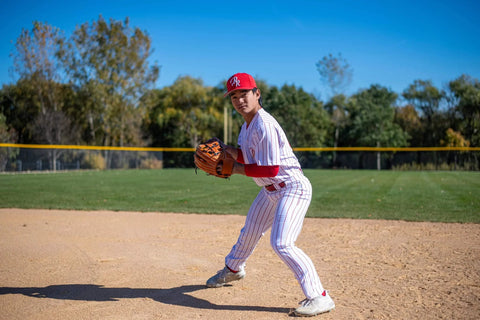 Baseball player wearing Pro Weight Four Way Stretch 14 Ounce Tapered Baseball Pants For Adults White With Black Pinstripes in action