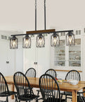 The Real Deal Five Light Farmhouse Chandelier With Slick Vintage Iron Frame And Crisp Clear Shades Giving Off Clean Modern Industrial Lighting Vibe For Dining Room Table Centerpiece over a wooden dining table surrounded by black chairs.