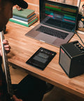Person playing guitar with Spark MINI 10W Portable Guitar Amp And Bluetooth Speaker With 8 Hour Battery Life on wooden desk