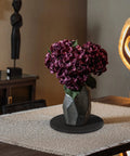 Slick 10 Inch Heavy Duty Swivel Base With A Slim Zero Point Eight Inch Profile And Rock Solid One Hundred Pound Support For Smooth 360 Degree Spin On Any Desk Or Counter For Monitors Plants And Everyday Tech Gear with purple flowers in geometric vase on table.