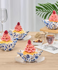 Decoratively frosted cupcakes in floral greaseproof liners on a table setting with wine and coffee, ideal for parties and events.