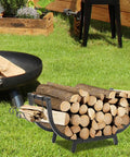 30-Inch Curved Firewood Rack, Heavy-Duty Steel Log Holder for indoor and outdoor use, with wood stacked in a garden setting.