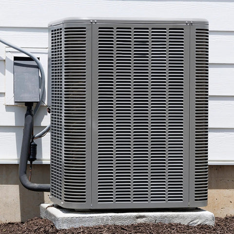 Outdoor air conditioning unit next to condenser with insulated pipes against white siding