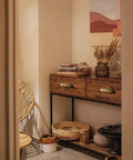 Decorated nook with wooden cabinet featuring antique brass cabinet pulls 5 inch center to center and decorative chair.