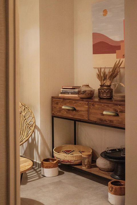 Decorated nook with wooden cabinet featuring antique brass cabinet pulls 5 inch center to center and decorative chair.