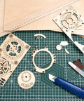 60-pack basswood laser-cut sheets, 12x12x1/8 in, square wood sheets; gears and crafting parts on cutting mat