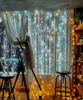 42.6 Foot Battery Powered Fairy Lights With 120 LEDs IP65 Waterproof Twinkle String With Timer And Eight Modes For Indoor And Outdoor Use No Fuss Christmas Tree Decor Warm White For Christmas Trees Weddings Parties And Cozy Bedroom Vibes illuminating a cozy room with warm white light.