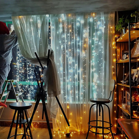 42.6 Foot Battery Powered Fairy Lights With 120 LEDs IP65 Waterproof Twinkle String With Timer And Eight Modes For Indoor And Outdoor Use No Fuss Christmas Tree Decor Warm White For Christmas Trees Weddings Parties And Cozy Bedroom Vibes illuminating a cozy room with warm white light.