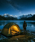Go To Family Size Four Person Camping Tent With Ultra Spacious Extended Floor Design lit by a lake with mountain backdrop at night