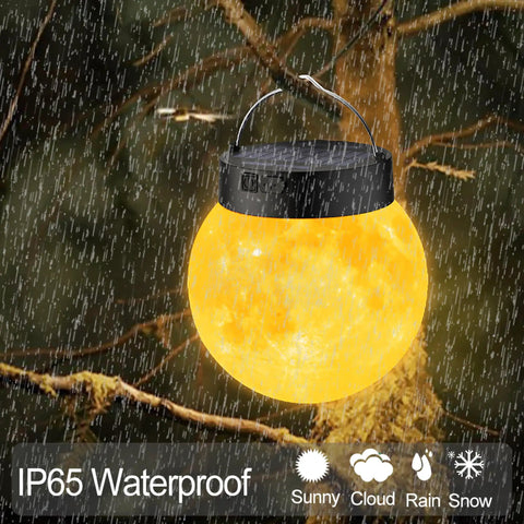Lit 3D Moon Globe Solar Garden Lights 2 Pack With Warm White LEDs Waterproof Outdoor Decor glowing at night in rain