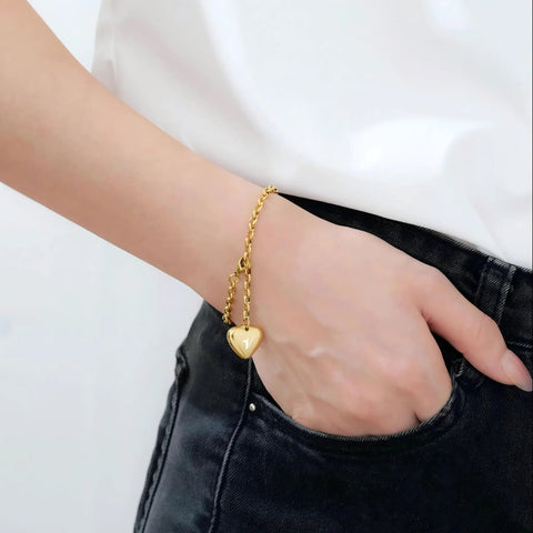 Woman wearing Stainless Steel Heart Pendant Bracelet For Women With A Z Letter Customization In Gold Or Silver Finish, Personalized Charm Jewelry For Her, Durable And Hypoallergenic, Rust Resistant, Gift Ready.