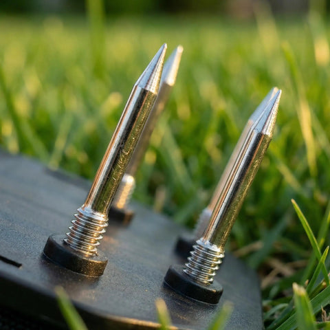 Close-up of stainless steel nails on heavy duty lawn aerator shoes with rust-resistant base and grass background.