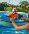 Child in orange shirt on Remote Control Baby Pool Float With Enclosed Propeller Guard, Motorized Toddler Boat For Ages 1 To 4