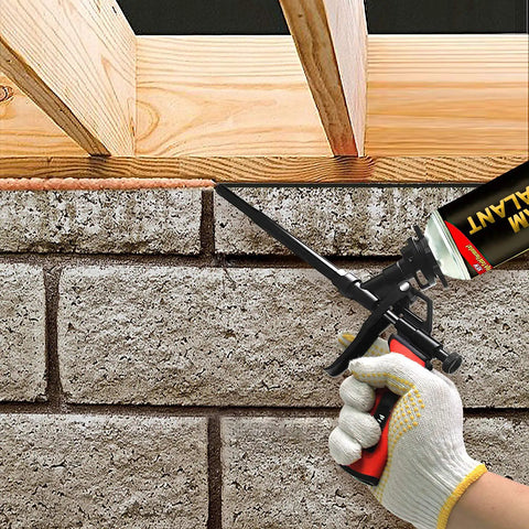 Heavy Duty Foam Gun For Caulking And Sealing used for applying foam between brick and wood structure, precise trigger control visible.