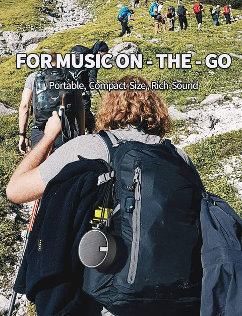 Hiker with backpack featuring Rugged IP67 Waterproof Bluetooth Speaker With Submersible Design, Portable Tiny Speaker attached