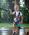 Child using Aluminum Zip Line Kit With Heavy Duty Pulleys And Quick Setup Trolley Slider For Backyard Or Park during rain.