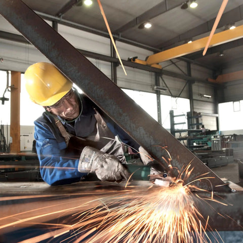 Worker using Flat Head Angle Grinder 4 1/2 to 5 Inch With 8 Amp Motor Aluminum Gearbox on metal beam in workshop