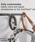 Person installing FastTrack 24 Piece Garage Wall Mounted Storage Kit with 6 Rails and 18 Hooks holding a bicycle