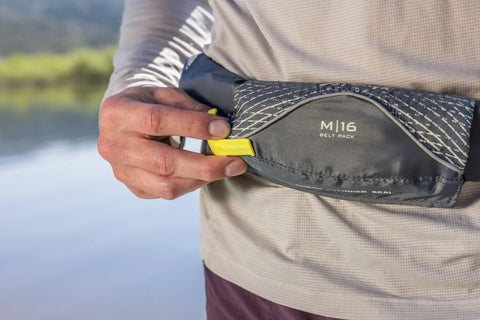 Close-up of the USCG Approved Manual Inflatable Belt Pack With Low Profile And 52 Inch Waist Fit on person's waist, showing M16 label.