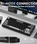 Compact 75 Percent Wireless Mechanical Gaming Keyboard With Hella Smooth Triple Connection Modes And A Massive Ten Thousand Milliamp Hour Battery on a desk with multiple devices.