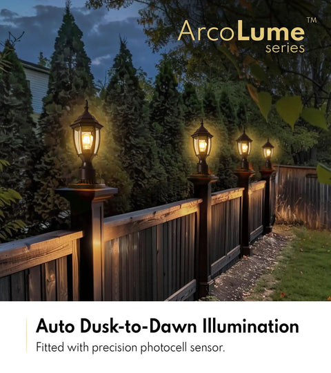 Row of dusk-to-dawn outdoor post lights illuminating a garden path and fence, focus on aluminum exterior lantern with pier mount, matte black finish.