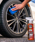 HydroSpin Wheel And Rim Ceramic Coating And Quick Detailer Spray 16 Oz used on a car tire with a blue sponge in hand