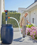 Man using Cordless Stick Water Transfer Pump With 6.5 Ft Extended Hose, Dual 4000mAh 21V Batteries, Makita Compatible, 720 Gallons Per Hour, 32 Ft Head to water flowers.