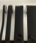 Straight Up Black Engineer Grade Reflective Tape That Goes Hard On Worksite Safety For Pipes And Bollards Smooth Flat Or Round Surfaces With Peel Off Acrylic Backing in various roll sizes on a grid background.