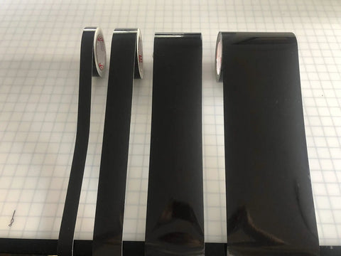 Straight Up Black Engineer Grade Reflective Tape That Goes Hard On Worksite Safety For Pipes And Bollards Smooth Flat Or Round Surfaces With Peel Off Acrylic Backing in various roll sizes on a grid background.