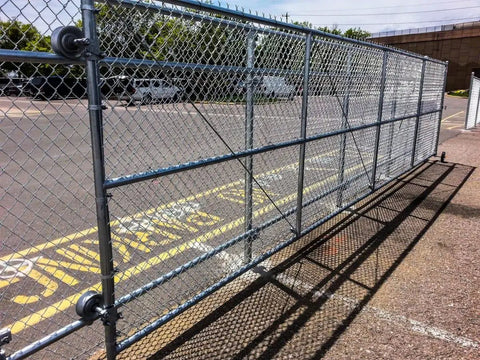 Heavy Duty Chain Link Sliding Gate Rollers Set with 5 Inch Wheels for 2-Inch Gate Frames installed in outdoor setting.