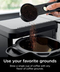 Hot And Iced XL Coffee Maker With Rapid Cold Brew Four Brew Styles Eight Cup Sizes From Small Cup To Travel Mug Barista Grade Single Serve Brewer 12 Cup Carafe Permanent Filter Removable Reservoir Black CM371, showing coffee grounds being added to filter.