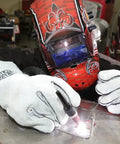 A welder wearing a helmet and Leather Welding Gloves KH641 Pro Grade Heat Resistant Gauntlet Cuff working on a metal surface.