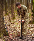 Man using 4-stage high-pressure PCP hand pump for air rifles, paintball, and tires, 5800 PSI, with moisture filter and gauge outdoors