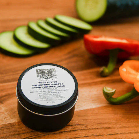 Wood Butter 4 Fl Oz Cutting Board Wax Conditioner For Butcher Block And Wooden Kitchen Tools All Natural Food Grade Mineral Oil And Beeswax jar on wooden surface next to vegetables.