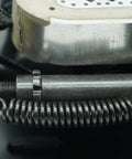 Close-up of a trailer brake magnet actuator with a coiled spring and a Dexter-branded brake rotor.