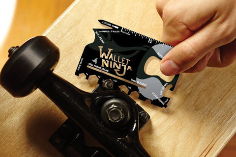 18 Tools In One Credit Card Sized Multitool For Quick Fixes And Everyday Carry being used on a skateboard, compact black gadget.