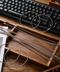 20 Pack Stainless Steel Wire Keychain Cables 11.8 Inch With 2mm Twist Barrel Screw Lock Rings on wooden tray near keyboard