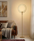 Eclipse Dope Bright Modern LED Torchiere Floor Lamp With Built In Touch Dimmer in gold next to a sofa in a living room