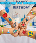 Children displaying science-themed temporary tattoos at a birthday party, featuring colorful lab and science icons.